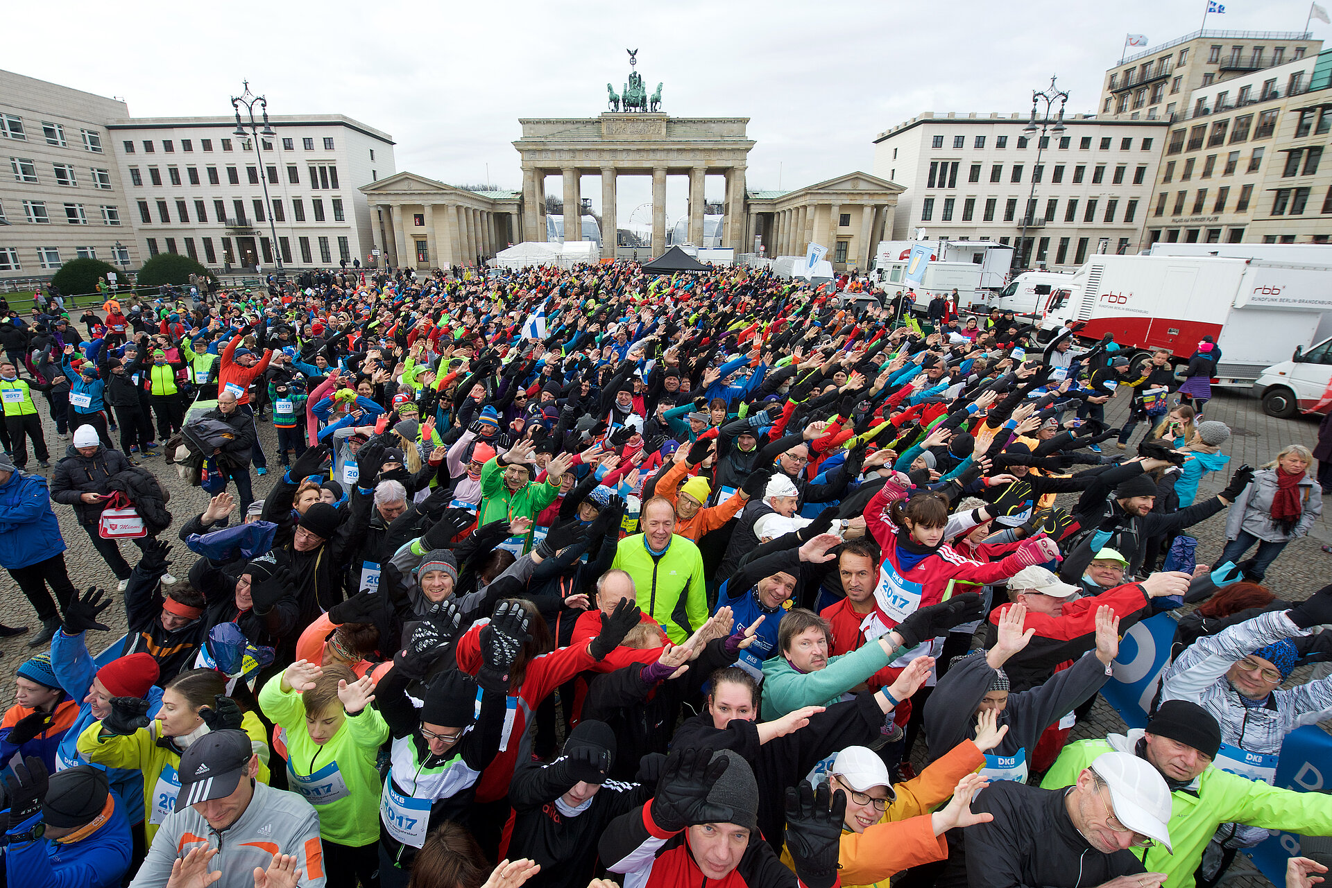 Berliner Neujahrslauf 2017: Teilnehmer am Start vor dem Brandenburger Tor winken gemeinschaftlich in die Kamera © SCC EVENTS / camera4