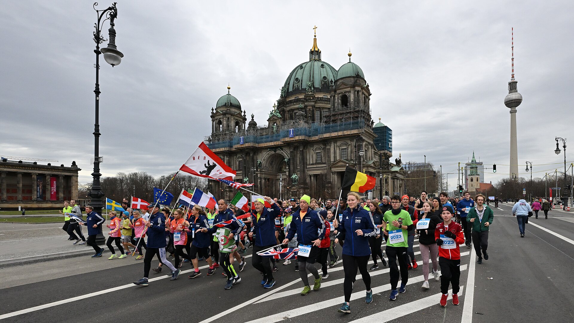 Berliner Neujahrslauf 2023: Läufer passieren den Berliner Dom, im Hintergrund der Fernsehturm © SCC EVENTS / Petko Beier